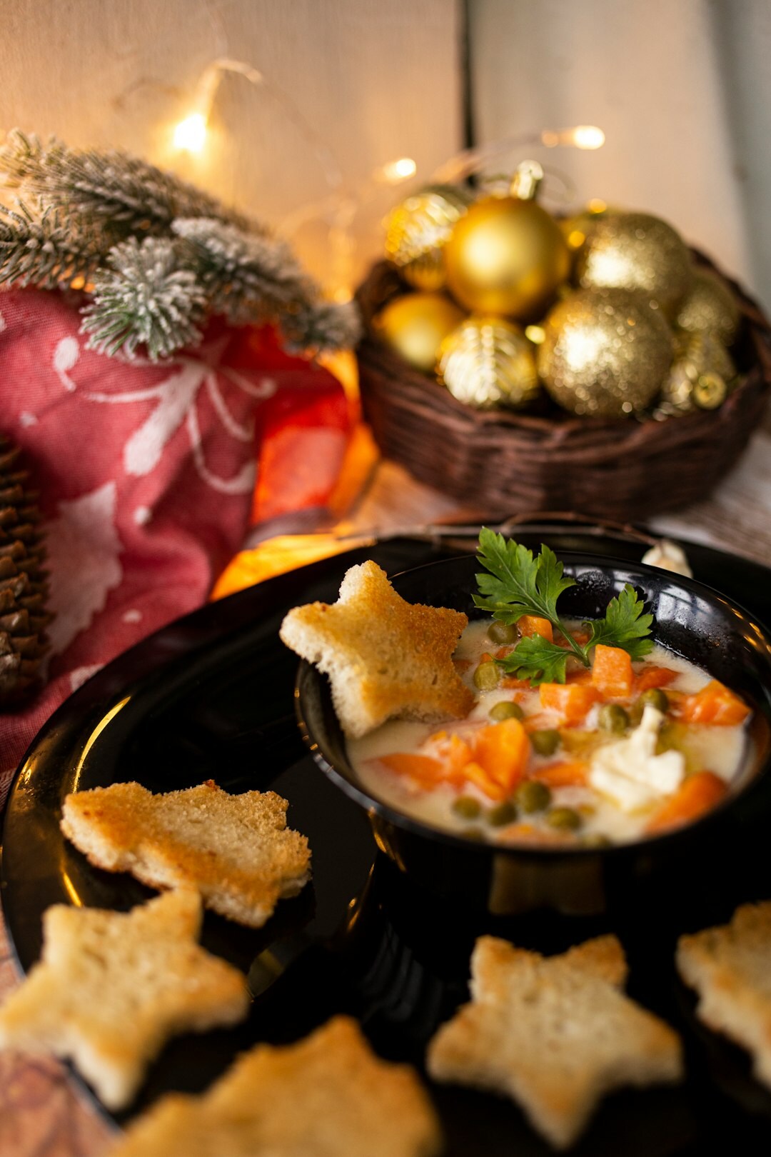 Bowl of hot soup and Christmas cookies on a table in winter